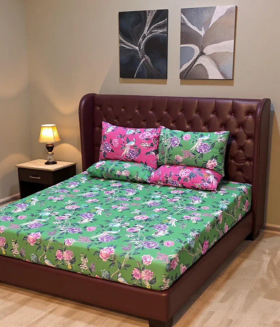 Bed with floral bedding and pink pillows in a room with abstract wall art.